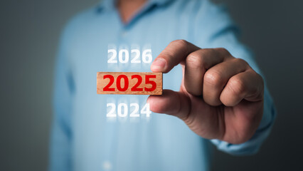 Businessman hand holding 2025 wooden block, Risk business and New Year New start concepts, 2025 goal planning, Countdown, business planning to 2025, Resolution, Strategy, Solution, Goal.