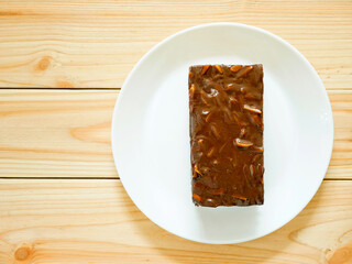 Chocolate cake with almonds on wooden table