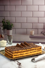 sweet dessert choco cake with chocolate cookies dulce de leche cream cheese on kitchen counter decorated with broken chocolate