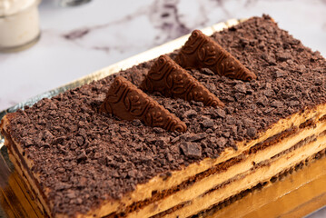 sweet dessert choco cake with chocolate cookies dulce de leche cream cheese on kitchen counter decorated with broken chocolate