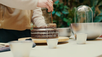 Eco crafting and home gardening, young man prepares a container for planting succulents in a glass...