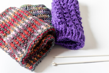 knitting with knitting needles and hand knit fabric on white background with knitting needles - colourful and knit texture with copy space 