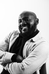 Confident smiling man in black and white portrait with crossed arms