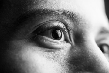 Close-up black and white human eye reflecting light