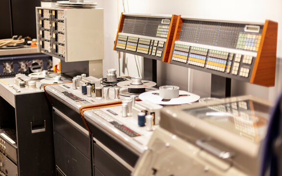 Vintage recording studio equipment with reel-to-reel tape machines and sound mixing panels.