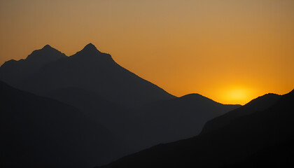 Obraz premium Stunning sunset mountain silhouette with vibrant orange sky and peaks