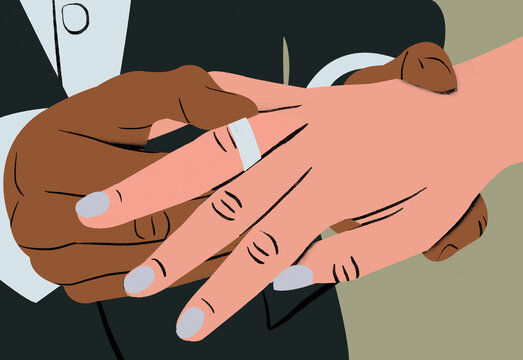Close-up of a handshake between two people with a focus on their hands against a neutral background.