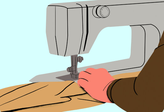 Close-up of hands sewing fabric with an industrial sewing machine on a light blue background.
