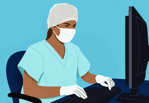 A healthcare professional in scrubs and a protective mask works attentively at a computer.
