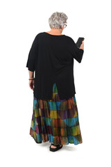 back view of senior woman walking and  looking at her mobile phone on white background