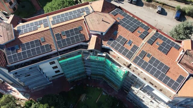 drone vista su palazzo in ristrutturazione con pannelli fotovoltaici e impalcature