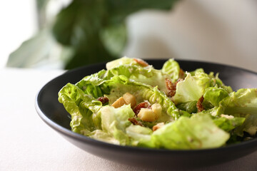 Caesar salad with croutons and parmesan cheese in black dish on white background italian food, italian culture