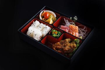 Tonkatsu and sashimi bento set japanese food isolate in black background