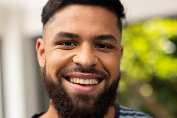 Obraz premium Smiling young man with beard enjoying outdoor time with friends