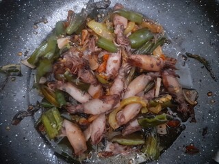 stir fried squid in a frying pan. background concept for food recipes, seafood, restaurant, lunch, breakfast, dinner, cuisine, protein, lifestyle, dish, cooking, ingredient, junk food, cholesterol