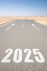 2025 is written on an asphalt road in the desert, blocked by dunes. A symbolic concept of future planning, challenges, and business obstacles