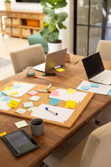 Fototapeta premium Working from home, laptops and tablets on table with sticky notes and coffee cups