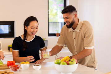 Friends in kitchen, enjoying drinks and preparing healthy meal together