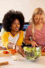 Preparing meal, young diverse friends chopping vegetables and enjoying cooking together