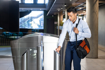 Entering office building, businessman using keycard at security turnstile gate © wavebreak3