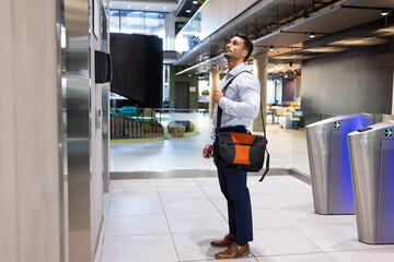 Businessman with shoulder bag waiting for elevator in modern office building © wavebreak3
