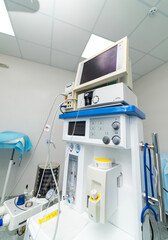 Daytime medical equipment setup. Modern medical equipment is arranged in a hospital room, ready for patient care with monitors and various devices.