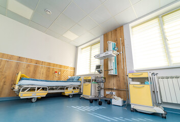 Clean hospital room with medical equipment and bed. A well-lit hospital room featuring a patient bed, medical equipment, and storage units