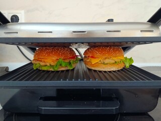 two burgers on the grill at home