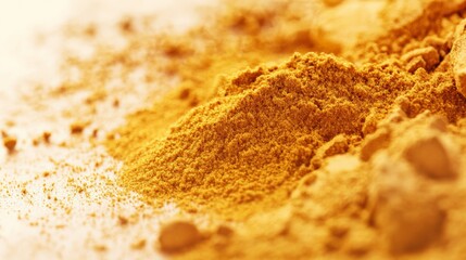 Close-up view of vibrant yellow turmeric powder with soft focus in the background, depicting its texture and vibrant color.