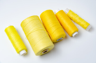 Yellow thread spools on white background.