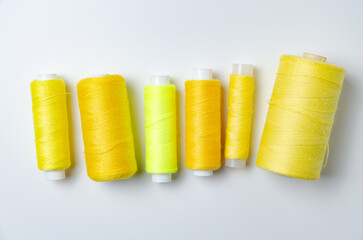 Yellow thread spools on white background.
