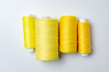 Yellow thread spools on white background.