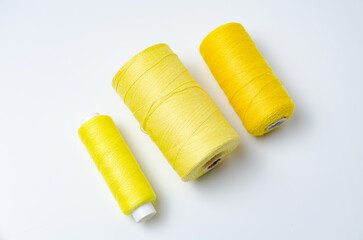 Yellow thread spools on white background.