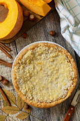 Fall traditional pumpkin pie with cinnamon on a rustic wooden background. Festive homemade Thanksgiving dessert.