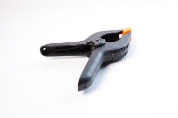 black orange plastic clamp (screen clamp) with a plain white background