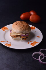 spicy chicken burger with onions pickles and lettuce on a brioche buns