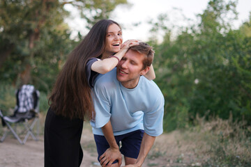 Obraz premium woman playfully jokes with her partner, who is bent over with laughter, while standing in a park on a sunny day