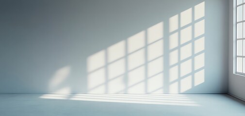 Obraz premium A minimalistic indoor space featuring soft natural light casting shadows on a blank wall, creating a serene atmosphere.
