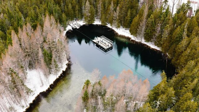 Lowering Aerial Shot Above Pond and Forest Winter