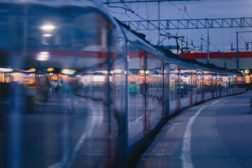 Fototapeta premium Electric train in the evening at the station. Railway platform.