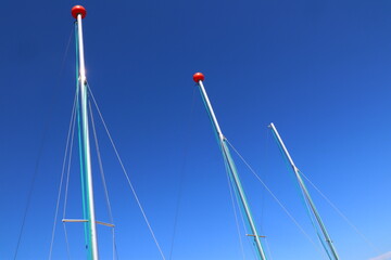 Obraz premium mast tips against the clear blue sky