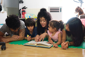 Young family is enjoying quality time together while reading a book at home