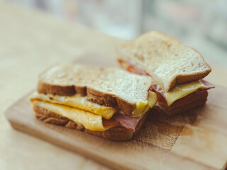 Close up homemade ham cheese sandwiches served on the wooden board.