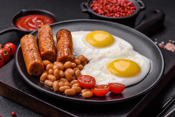 Full English breakfast with boiled eggs, beans, sausages, tomatoes