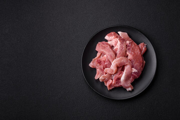 A pieces of raw fresh pork on a wooden cutting board with spices and herbs