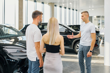 Business concept, man and woman came to car dealership to buy a car