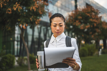 Fototapeta premium Mature japanese businesswoman study documents in an outdoor setting
