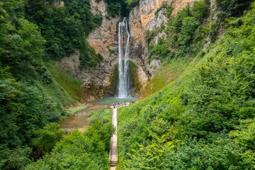 A beautiful waterfall with a wooden path to it surrounded by greenery - Bliha waterfall near Sanski Most in Bosnia and Herzegovina