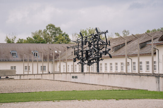 Munich, Germany - September 13, 2024 - sculpture at the Dachau Concentration Camp Memorial in Germany, representing the suffering of prisoners. Buildings are visible in the background.