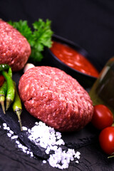 ingredients for making hamburger. fresh ground meat with seasonings. fresh vegetables.